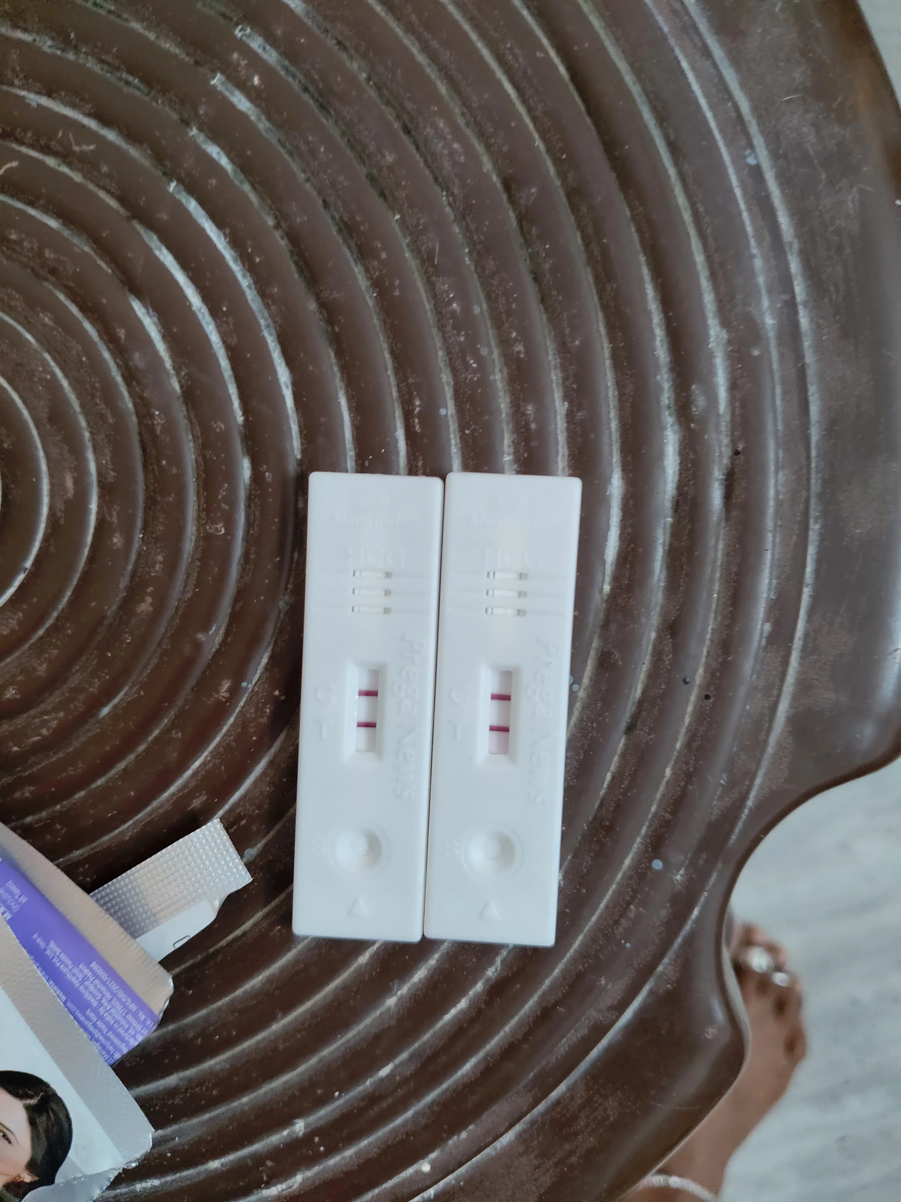 Two pregnancy test strips both showing two clear pink lines, a positive result on Pregaview Hcg test cards
