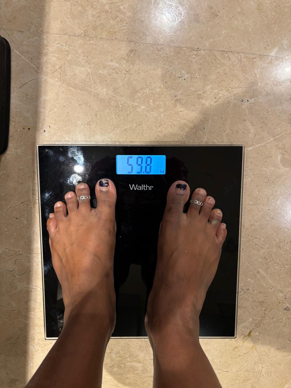 Weighing scale showing 59.8 kg after the program
