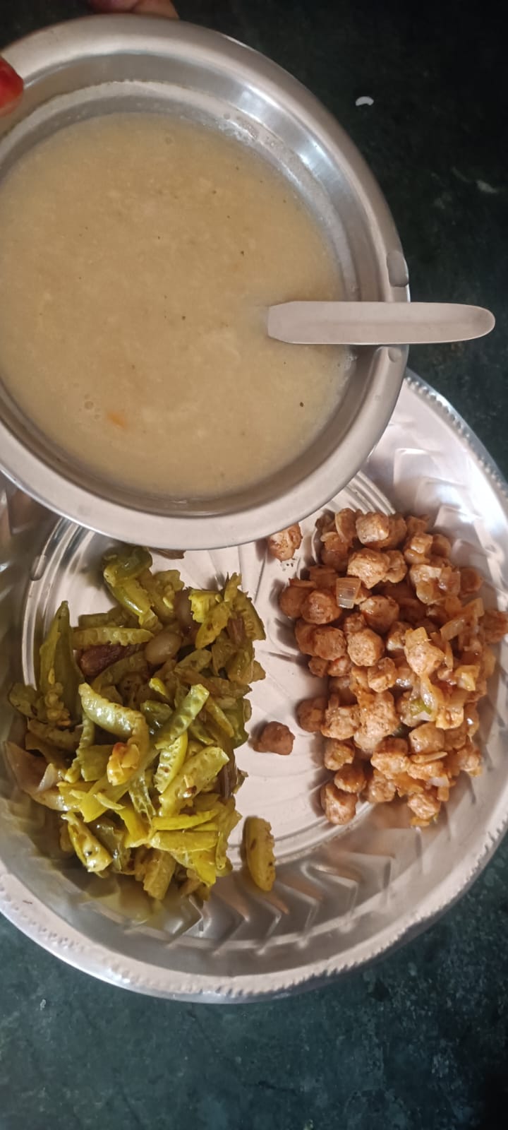 A tumbler of health-mix porridge served with a cluster-beans poriyal and a soya-chunk curry