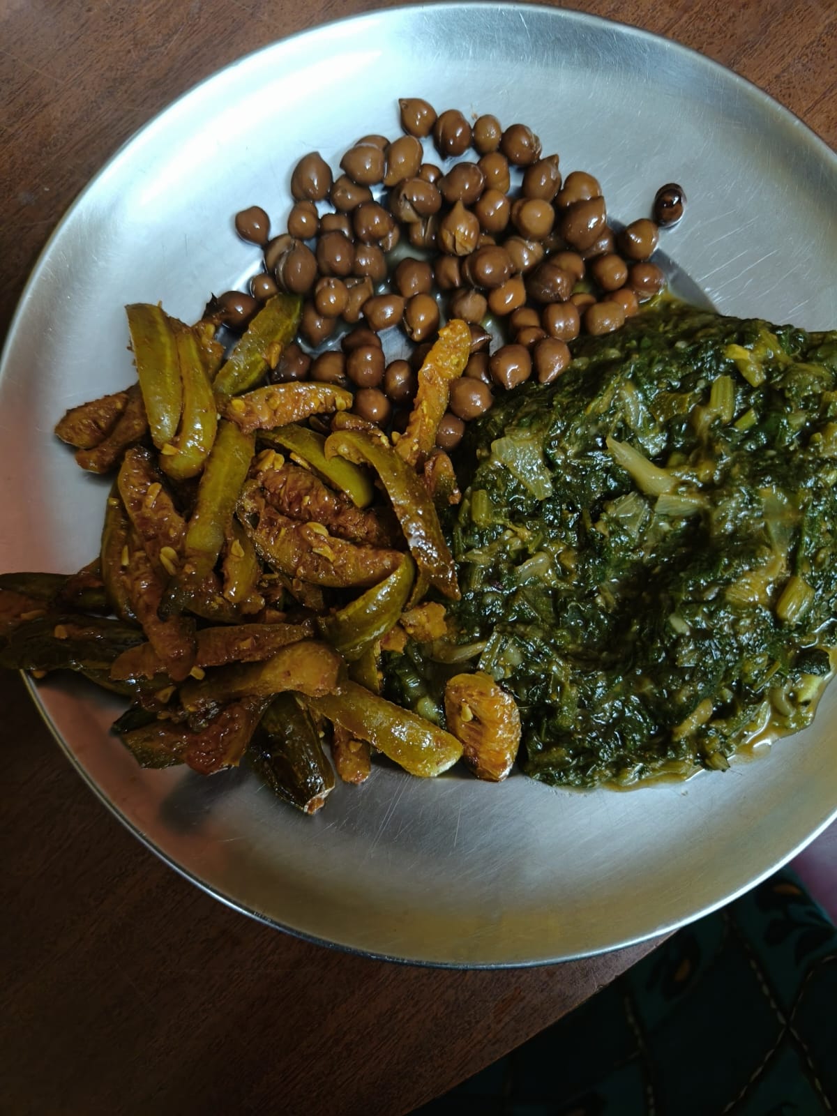 A steel plate with black chana, a tindora poriyal and a keerai masiyal