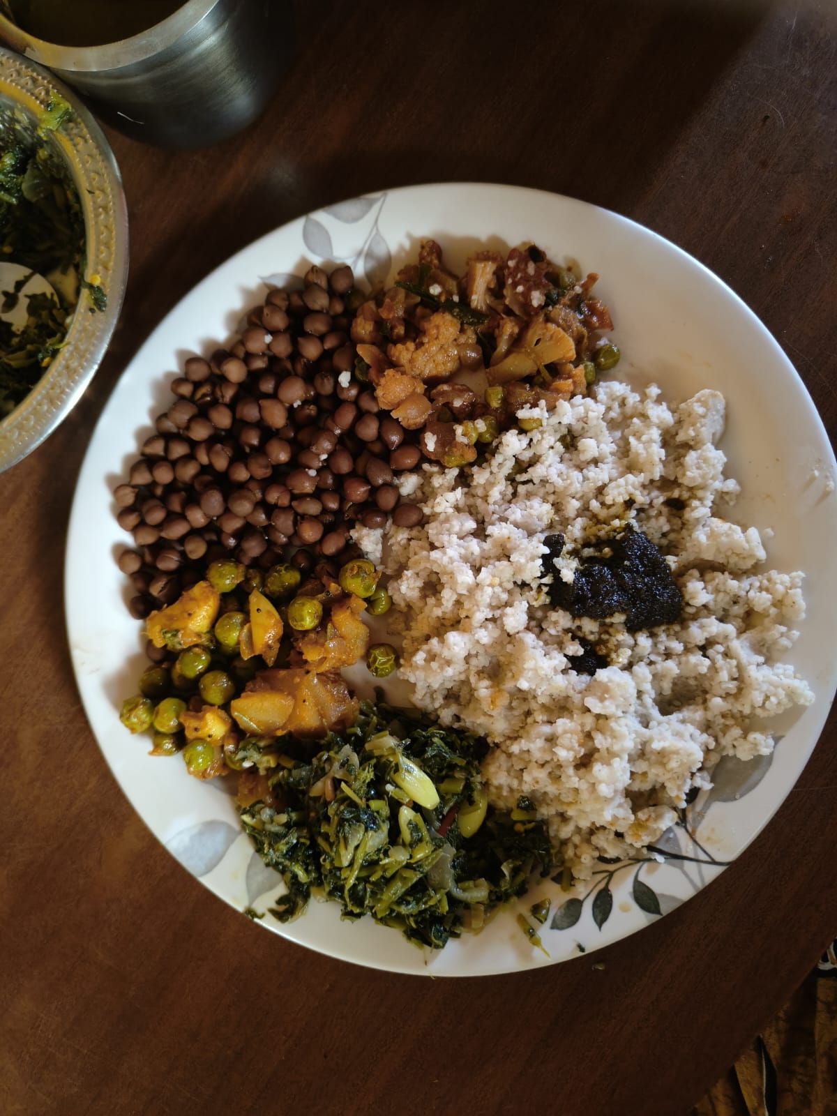 A plate with black chana, a green-peas curry, white kali, a greens poriyal and a little pickle