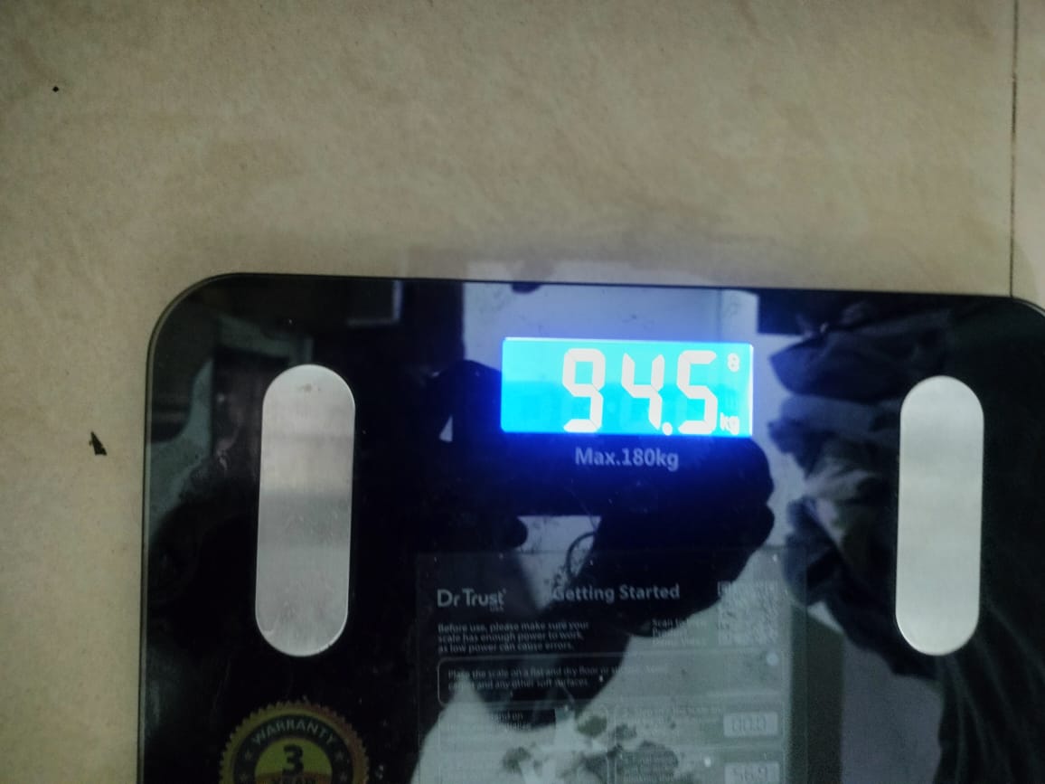 A digital scale reading 94.5 kg, Mohan's weight after the program