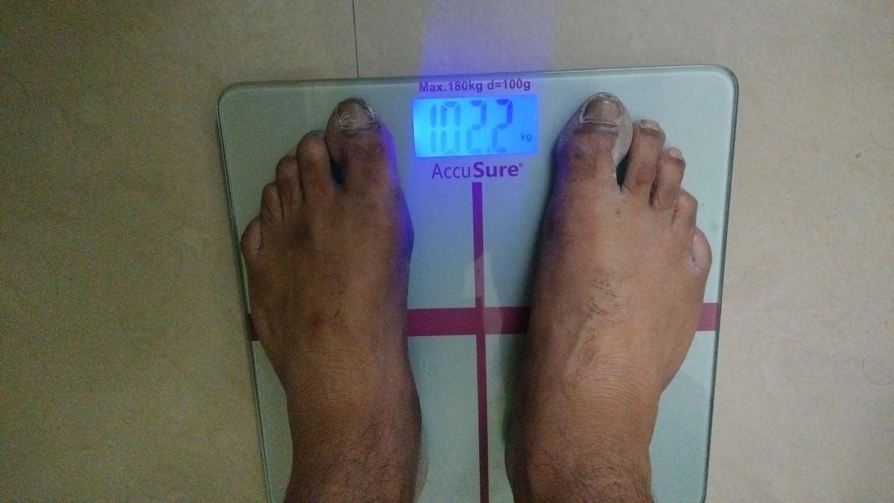 A digital scale reading 102.2 kg, Mohan's starting weight