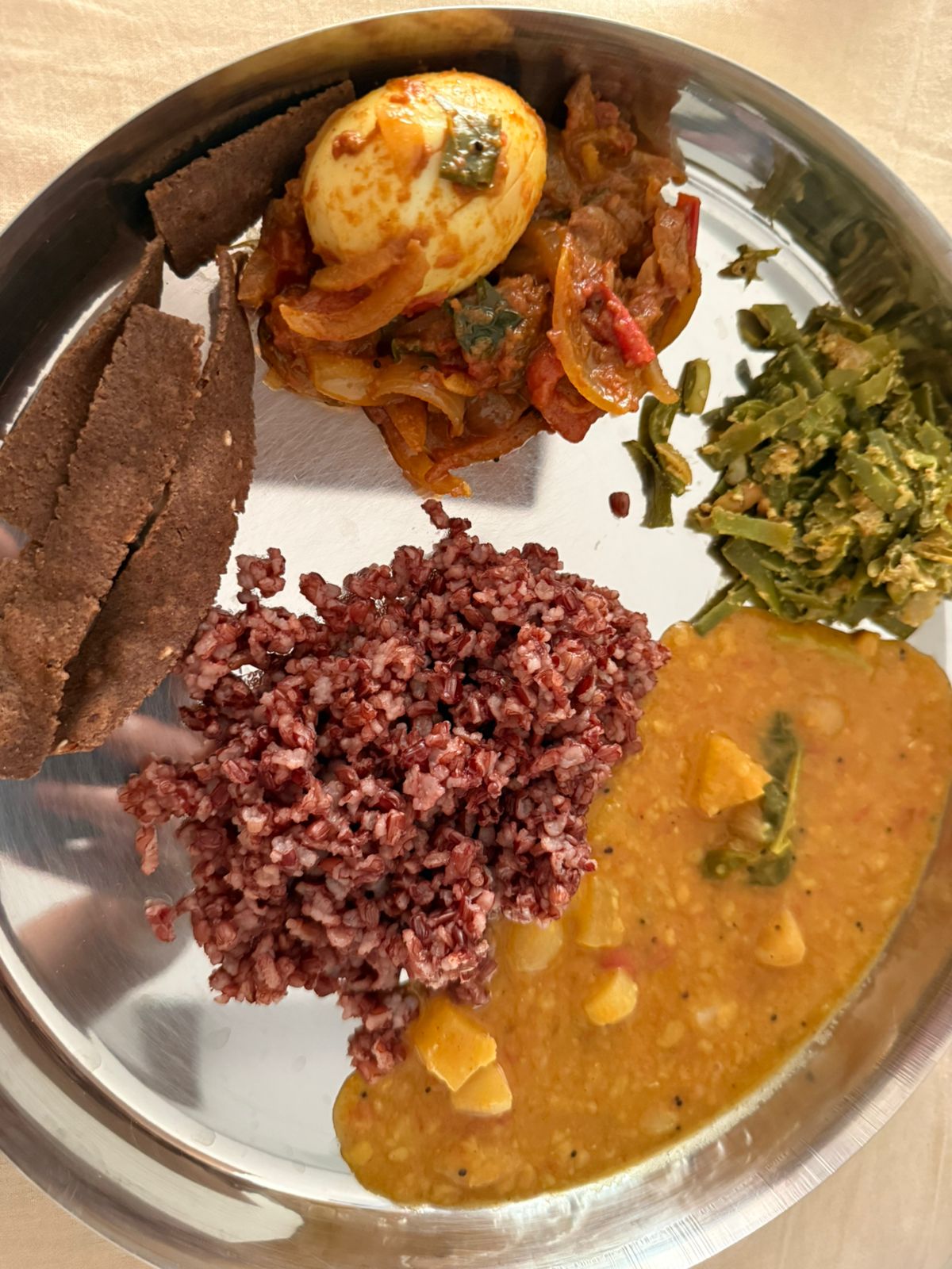 One of Anitha's plates: red rice, egg curry, dal and beans poriyal